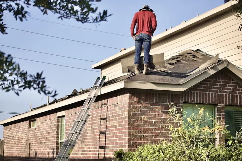 Professional roofer working on a residential roof in East Woods